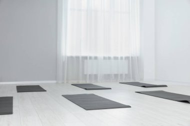 Egzersiz paspasları olan geniş bir yoga stüdyosu. Metin için boşluk