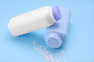 Açık mavi arka planda şişeler ve toz alma tozu. Bebek kozmetik ürünleri