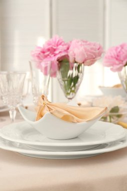 Güzel şakayık ve kumaş peçeteli şık bir masa.