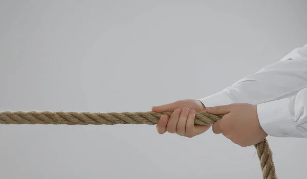 Concepto Disputa Hombre Tirando Cuerda Sobre Fondo Gris Claro Primer — Foto de Stock