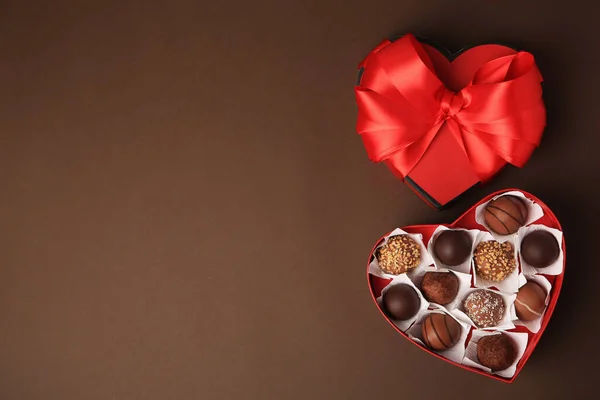 Caixa Forma Coração Com Deliciosos Doces Chocolate Fundo Marrom Flat — Fotografia de Stock