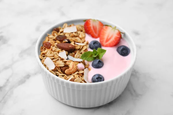 味道鲜美的格拉诺拉 酸奶和新鲜的浆果在白色大理石桌上的碗里 健康早餐 — 图库照片