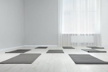 Egzersiz paspasları olan geniş bir yoga stüdyosu. Metin için boşluk