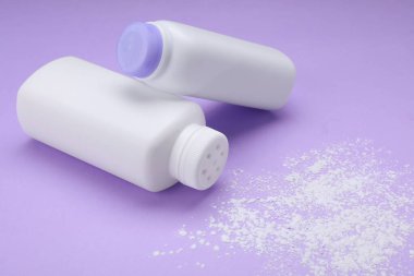 Şişe ve toz tozları menekşe arka planda. Bebek kozmetik ürünleri