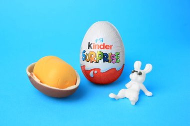 Slynchev Bryag, Bulgaristan - 25 Mayıs 2023: Açık mavi arka planda Kinder Sürpriz Yumurtaları, plastik kapsül ve oyuncak tavşan