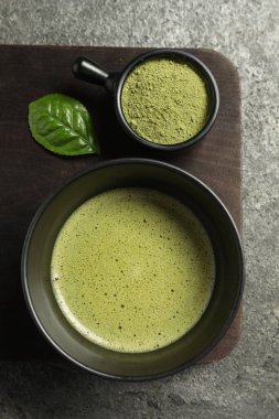 Bir fincan taze kibrit çayı ve yeşil pudra gri masada, üst tarafta.