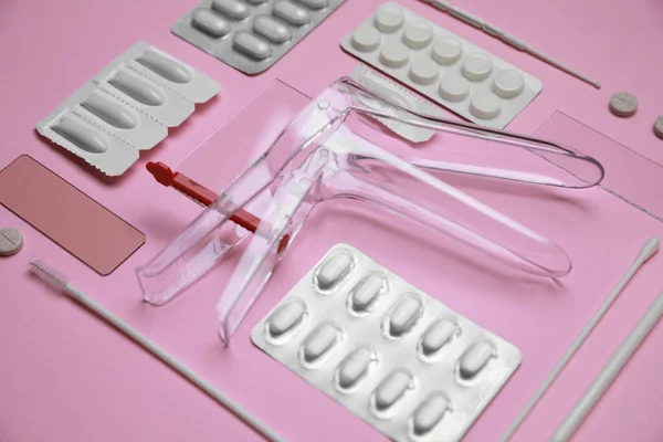 Sterile gynecological examination kit and medicaments on pink background