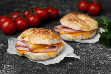 Jambon ve peynirli lezzetli simit koyu gri desenli masa, metin için yer var.