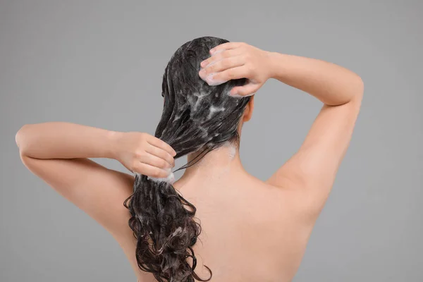 Γυναίκα Πλύσιμο Των Μαλλιών Γκρι Φόντο Πίσω Όψη — Φωτογραφία Αρχείου