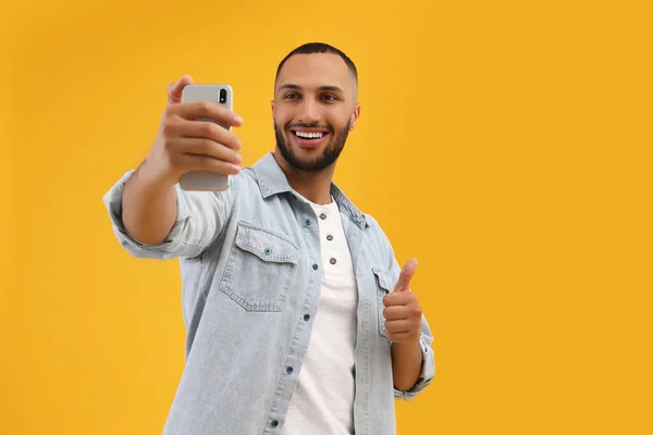 Joven Sonriente Tomando Selfie Con Smartphone Mostrando Los Pulgares Hacia —  Fotos de Stock