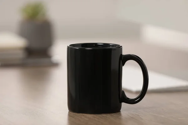 職場での木製テーブルの上に黒いセラミックマグカップ — ストック写真