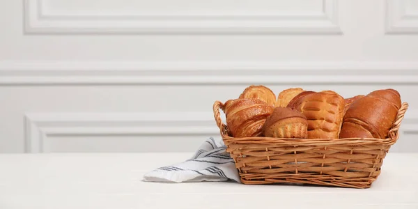 Wicker Basket Different Tasty Freshly Baked Pastries White Wooden Table — Stock Photo, Image