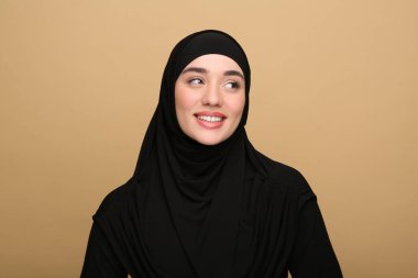 Bej arka planda tesettürlü Müslüman kadın portresi