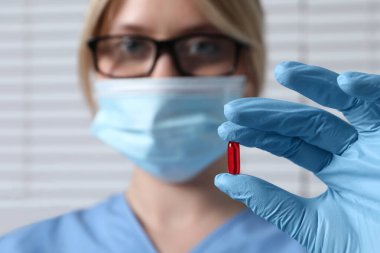 Doktor arka planda hap tutuyor, seçici odaklanma. Metin için boşluk