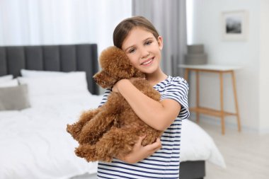 Yatak odasında köpek yavrusu olan küçük bir çocuk. Sevimli hayvan