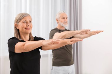 Yaşlı çift evde yoga yapıyor, seçici odaklanma.