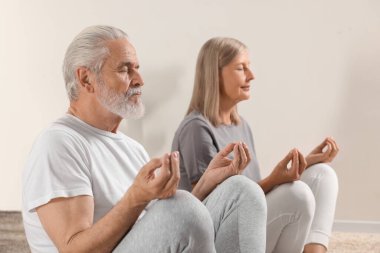 Yaşlı çift evde yoga yapıyor, seçici odaklanma.