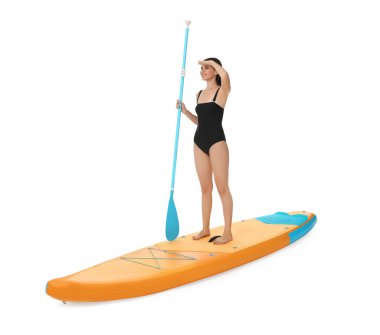 Beyaz arka planda turuncu SUP tahtasıyla kürek çeken mutlu bir kadın.