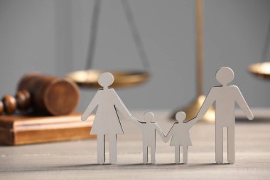Aile hukuku. Çocuklu ebeveyn figürü, teraziler ve tahta masa üzerindeki tokmak, metin için alan
