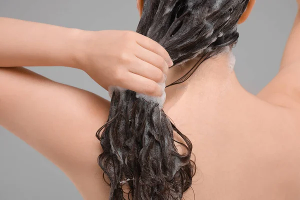 Žena Praní Vlasů Šedém Pozadí Detailní Záběr — Stock fotografie