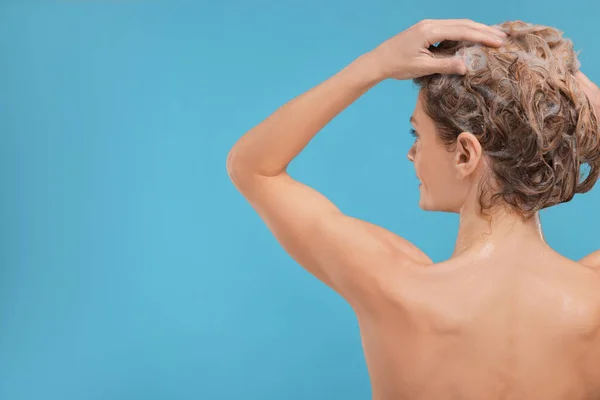 女人在浅蓝色的背景上洗头发 后视镜 案文的篇幅 — 图库照片