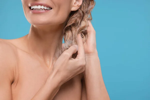 Uśmiechnięta Kobieta Myjąca Włosy Jasnoniebieskim Tle Zbliżenie Miejsce Tekst — Zdjęcie stockowe