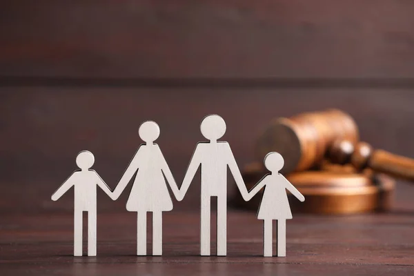 Family law. Figure of parents with children and gavel on wooden table