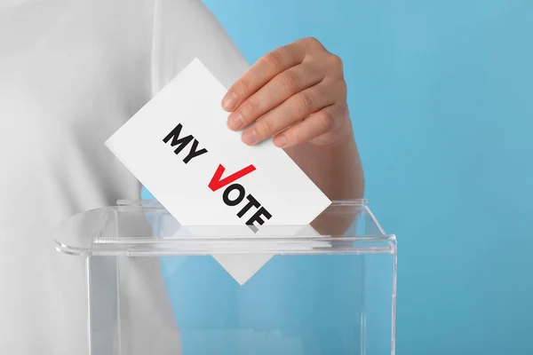 女性はテキストで紙を置く 私の投票し ライトブルーの背景に投票箱にチェック — ストック写真