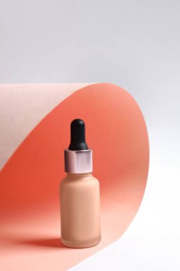 Renkli arka planda bir şişe deri. Makyaj ürünü