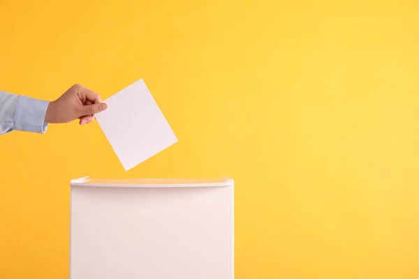 Woman Putting Her Vote Ballot Box Orange Background Closeup Space — Stock Photo, Image
