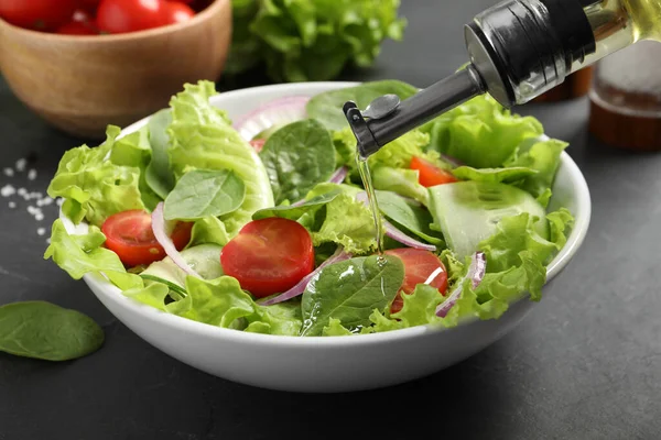 Nalévání Oleje Lahodného Zeleninového Salátu Šedém Stole Detailní Záběr — Stock fotografie