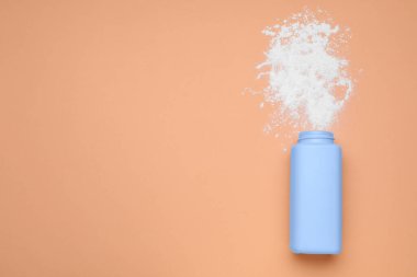 Soluk mercan zemin üzerinde şişe ve toz alma tozu, üst görünümü metin için alan. Bebek kozmetik ürünü