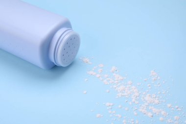 Açık mavi arka planda şişe ve toz alma tozu. Bebek kozmetik ürünü