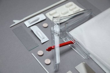 Steril jinekolojik muayene kiti ve gri arka planda ilaçlar