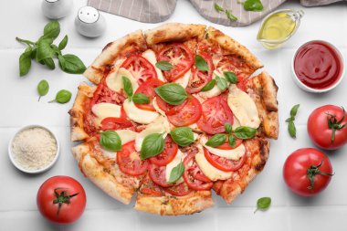 Lezzetli Caprese pizzası ve malzemeler beyaz fayanslı masada, düz yerde.