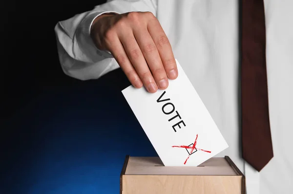 Man Putting Paper Word Votar Marcar Las Urnas Sobre Fondo —  Fotos de Stock