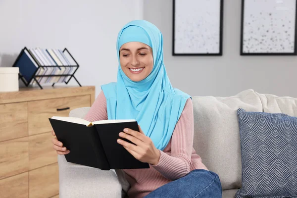 Мусульманська Жінка Читає Книгу Дивані Кімнаті — стокове фото