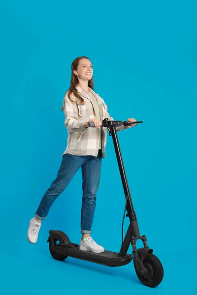 Mutlu Kadın Açık Mavi Arka Planda Modern Elektrikli Scooter Kullanıyor — Stok fotoğraf
