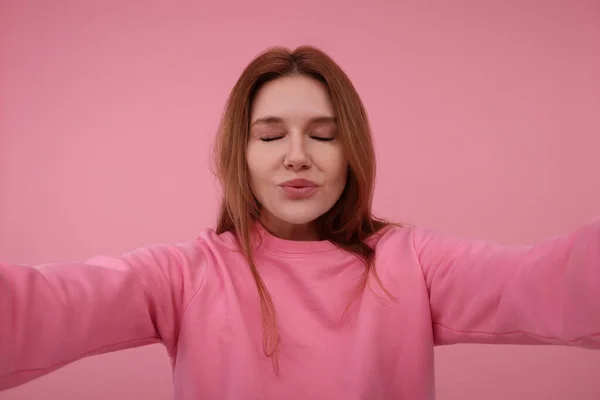 stock image Beautiful woman taking selfie on pink background