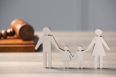 Aile hukuku. Çocuklu ebeveyn figürü ve tahta masa üzerinde tokmak, metin için alan