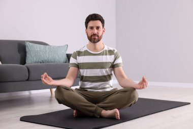Adam evde meditasyon yapıyor. Ahenk ve zen