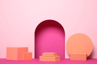 Pembe arka planda birçok turuncu geometrik figür. Ürün için stil sunumu