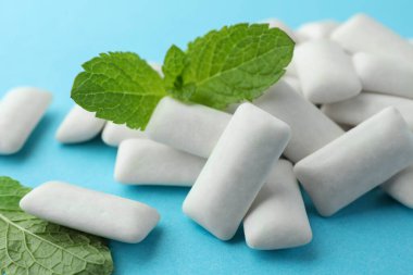 Lezzetli beyaz diş eti yığını ve açık mavi arka planda nane yaprakları, yakın plan.