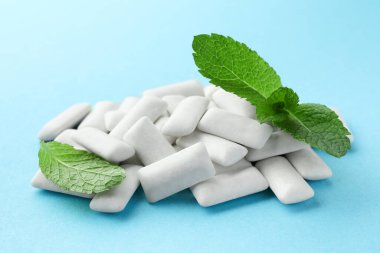 Lezzetli beyaz diş eti yığını ve açık mavi arka planda nane yaprakları, yakın plan.