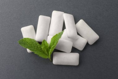 Gri arka planda lezzetli beyaz sakız ve nane yaprakları, üst manzara.