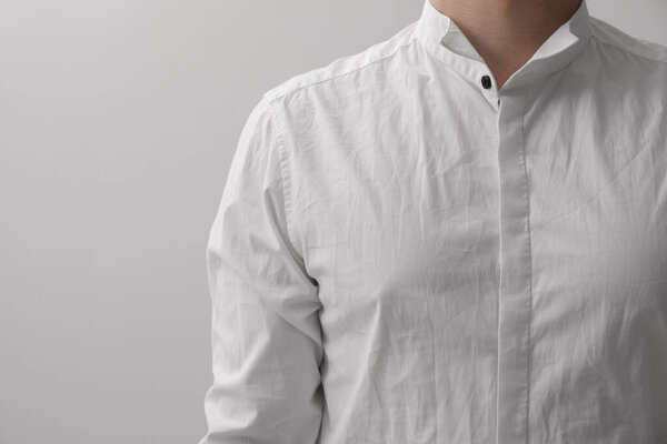 Man wearing rumpled shirt on white background, closeup