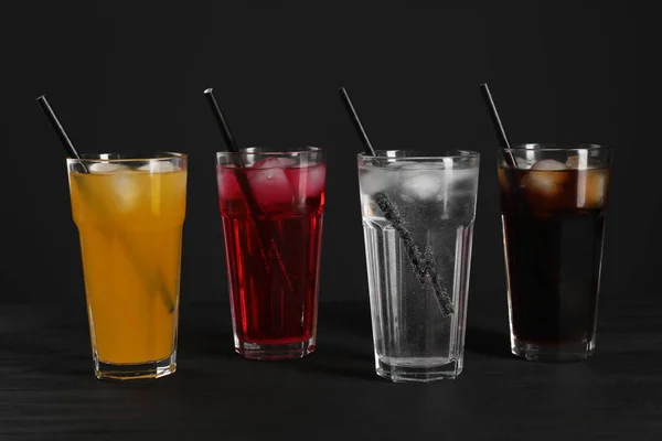 Farklı Tazeleyici Soda Bardakları Buz Küpleri Siyah Masa Üzerinde Pipetler — Stok fotoğraf