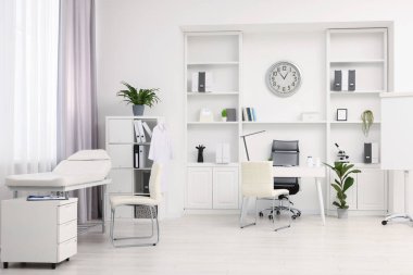 Doktorun çalışma alanı ve muayene masası olan modern tıp bürosu