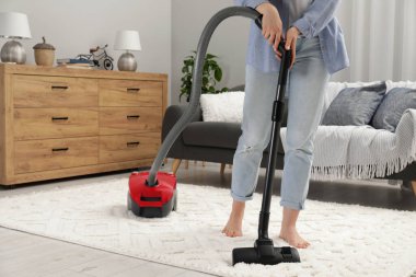 Halıyı elektrikli süpürgeyle temizleyen kadın, yakın çekim.