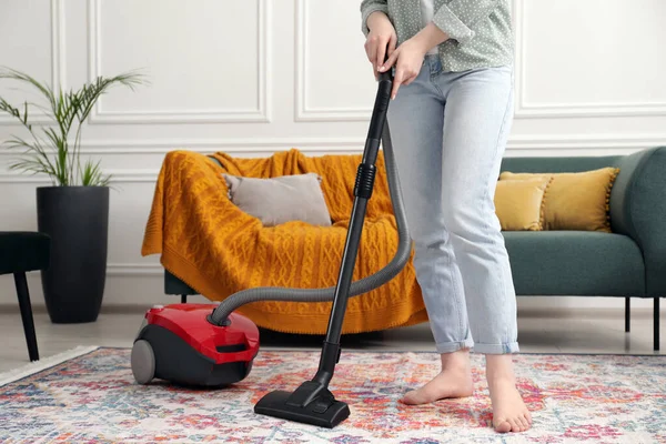 Halıyı elektrikli süpürgeyle temizleyen kadın, yakın çekim.